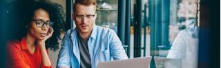 vrouw en man achter laptop